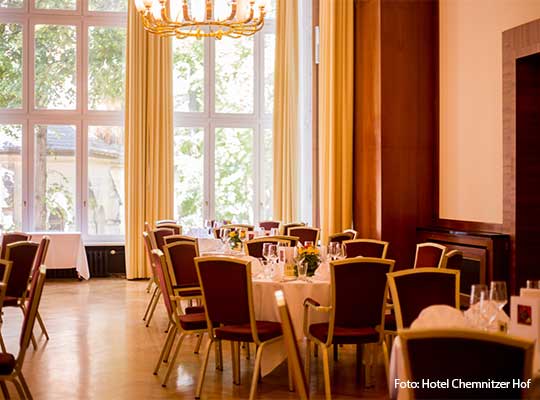 Saal mit gelben Vorhängen, dunkelroten Stühlen und dem Blick nach draußen beim Krimidinner Chemnitz