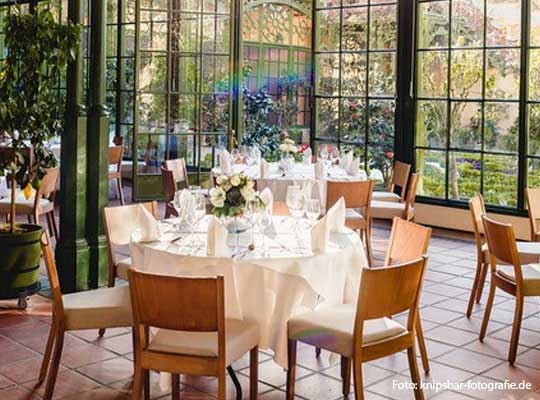 Schöner Wintergarten gedeckt beim Krimidinner Schwerin., Plfanzen und Gräser im Hintergrund, perfektes Zusammenspiel zwischen Natur und Moderne